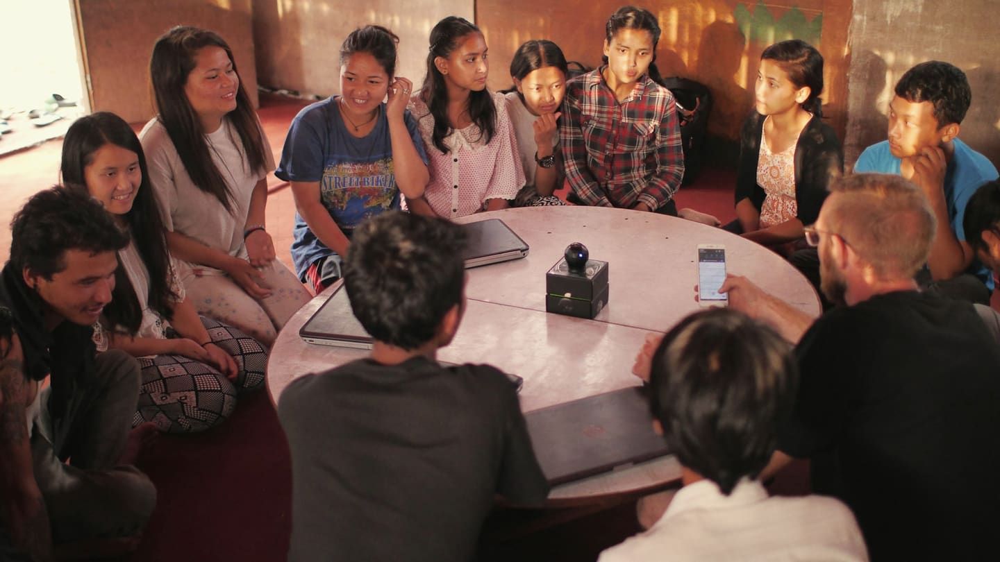 A small group seated in a circle in conversation