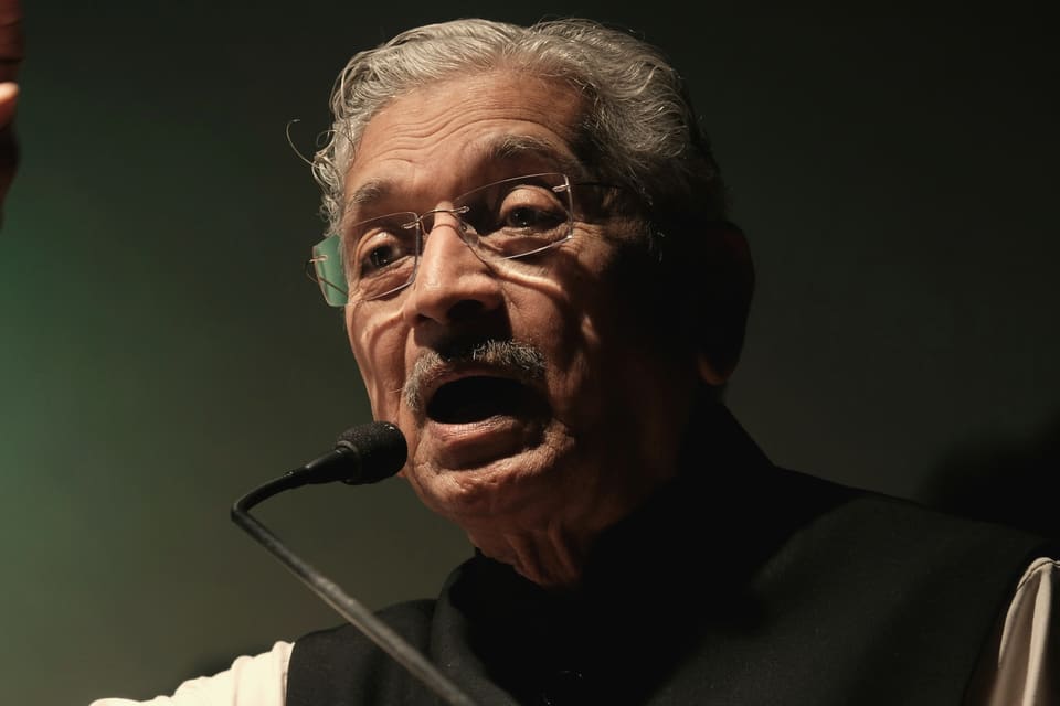A speaker addresses the room with a microphone