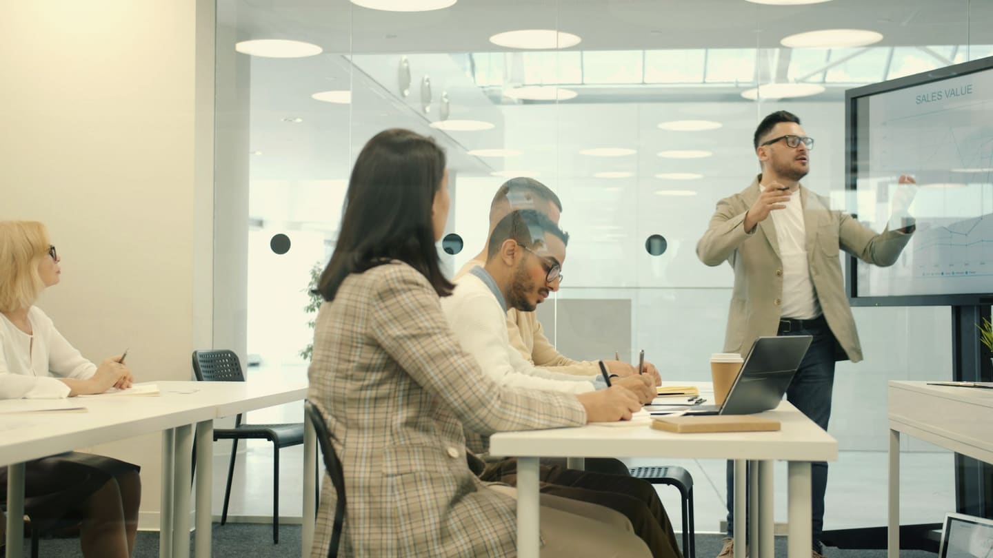 A facilitator presents to colleagues in a meeting room