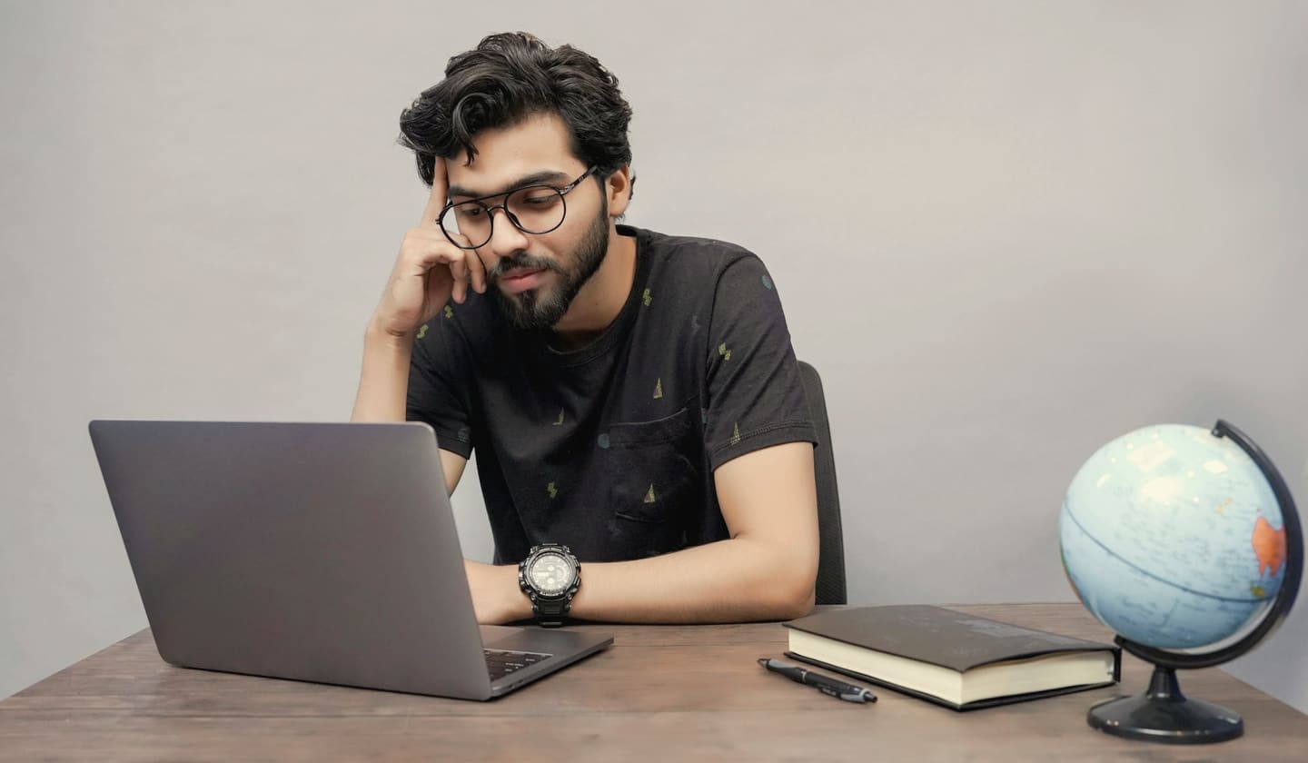 A young man pausing to reflect while working