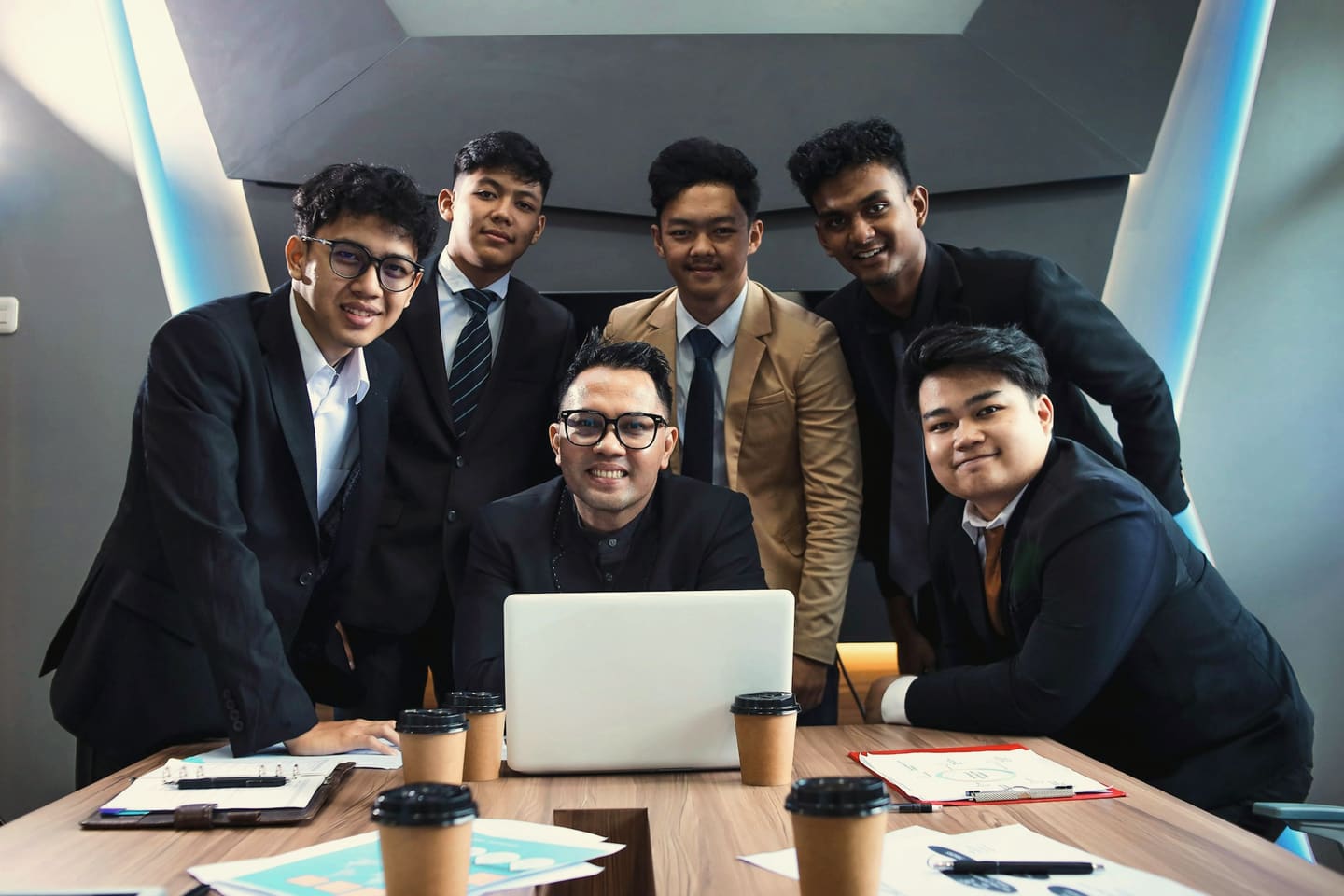A young team gathered around a laptop